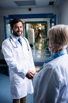 Doctors shaking hands in corridor