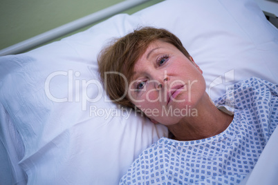 Portrait of sad senior patient lying on a bed