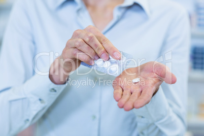 Pharmacist taking pills in pharmacy