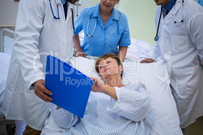 Doctors showing medical report to patient