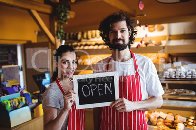 Couple holding open signboard