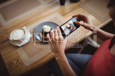 Woman taking a photo of sweet food from mobile phone