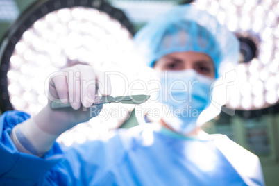 Female surgeon holding medical equipment in operating room