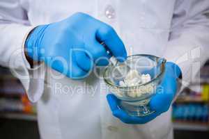 Pharmacist grinding medicine with mortar and pestle