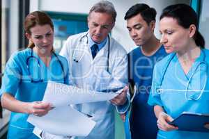 Doctor and surgeons discussing with report in surgical room