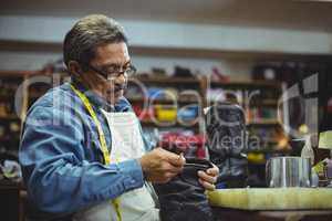 Shoemaker applying glue on shoe