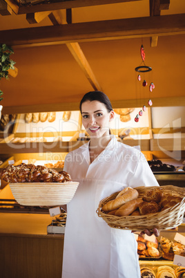 Female baker holding basket of sweet foods