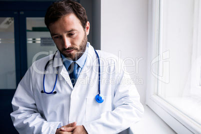 Sad doctor standing in corridor