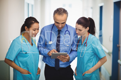 Doctor and nurses discussing over digital tablet