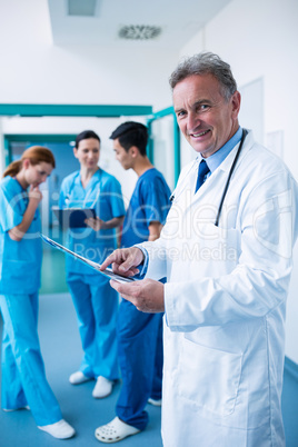 Portrait of smiling doctor standing with x-ray report in corrido