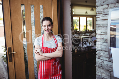 Portrait of female baker standing with arms crossed