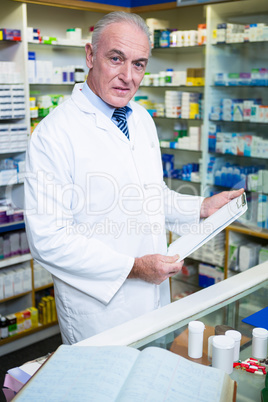 Pharmacist holding a clipboard in pharmacy