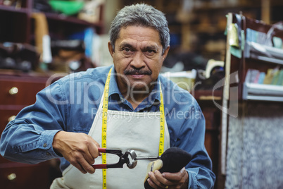 Portrait of shoemaker hammering on a shoe