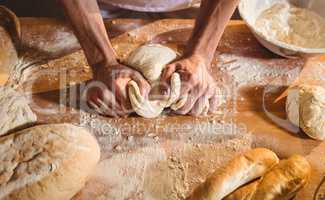 Hands of baker kneading a dough