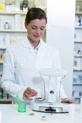 Pharmacist measuring tablets with pharmacy scale