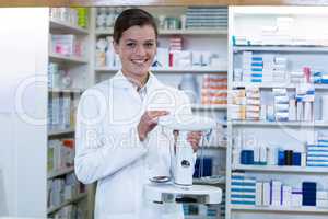 Pharmacist measuring tablets with pharmacy scale in pharmacy