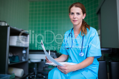 Portrait of nurse holding medical report