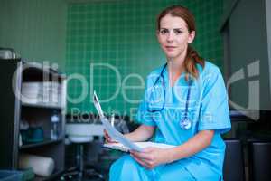 Portrait of nurse holding medical report