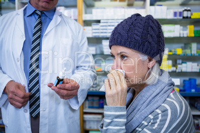 Pharmacist showing medicine to customer