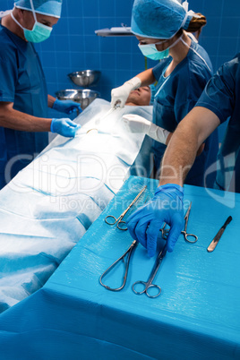 Surgeon taking a scissors from tray