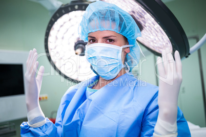 Portrait of female surgeon showing surgical gloves