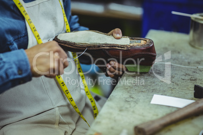 Shoemaker repairing a shoe