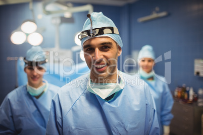 Portrait of surgeon and nurses standing in operation room