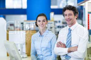Smiling pharmacists standing at counter in pharmacy