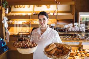 Female baker holding basket of sweet foods