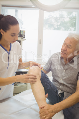 Female doctor examining patients knee