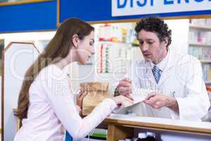 Pharmacist explaining prescriptions to customer
