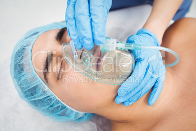 Nurse putting an oxygen mask on patient