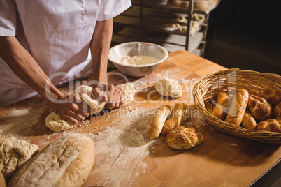 Mid-section of baker kneading a dough