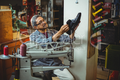 Shoemaker examining a shoe