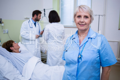 Portrait of nurse standing in hospital room