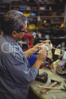 Shoemaker examining a high heel