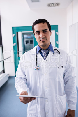 Doctor holding digital tablet in hospital corridor Doctor holding digital tablet in hospital corridor