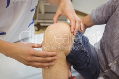 Close-up of female doctor examining patients knee