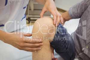 Close-up of female doctor examining patients knee
