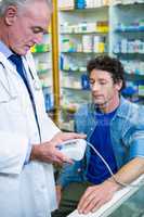 Pharmacist checking blood pressure of customer