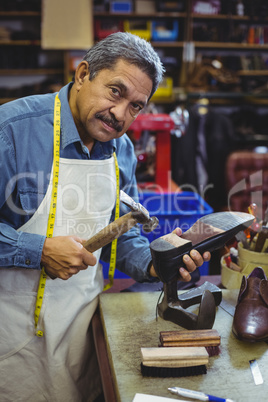 Portrait of shoemaker hammering on a shoe