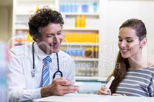 Customer and pharmacist reading pregnancy test
