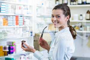 Pharmacist holding a medicine bottle in pharmacy