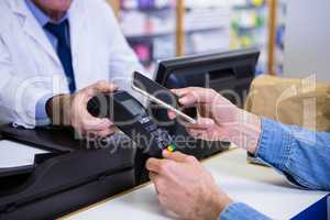 Customer making payment through smartphone in payment terminal