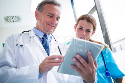 Doctor and nurse discussing over digital tablet