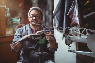 Shoemaker examining a shoe