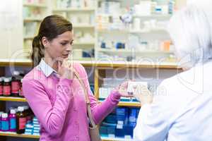 Pharmacist assisting the box of medicine to customer