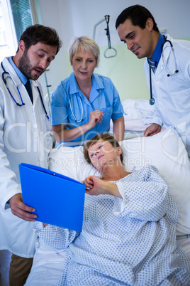 Doctors showing medical report to patient