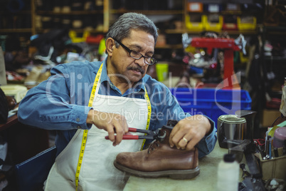 Shoemaker repairing a shoe
