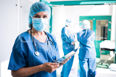 Surgeon using digital tablet in corridor